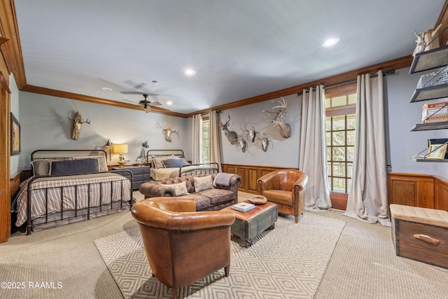 carpeted living room with a healthy amount of sunlight, crown molding, and a wainscoted wall