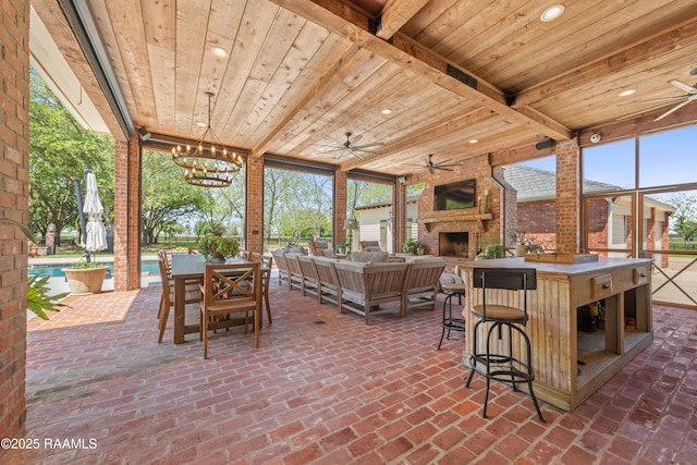 view of patio / terrace with a ceiling fan, an outdoor pool, an outdoor living space with a fireplace, and outdoor dry bar