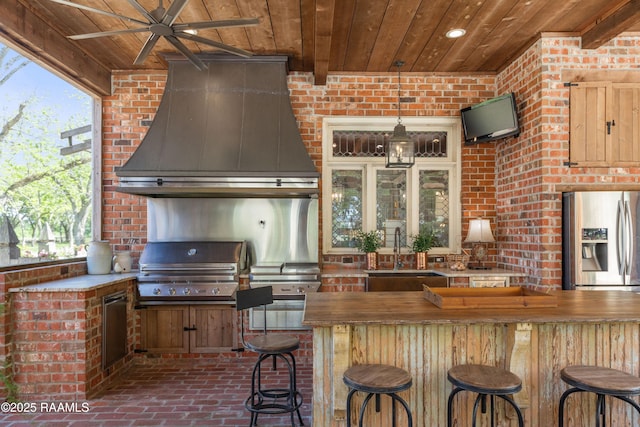 view of patio with a ceiling fan, a sink, outdoor wet bar, exterior kitchen, and area for grilling