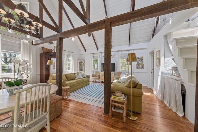 living room with light wood-type flooring, a healthy amount of sunlight, and beam ceiling