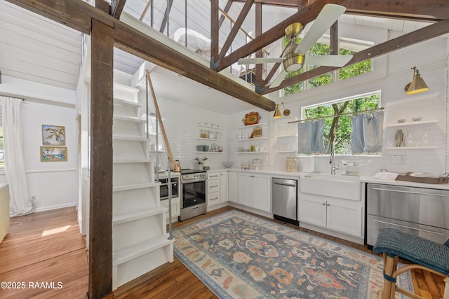 kitchen featuring beam ceiling, open shelves, light wood-style floors, white cabinets, and appliances with stainless steel finishes