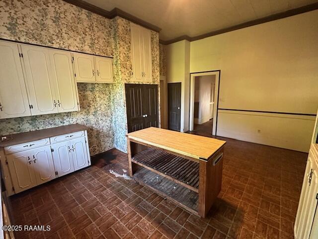 505 Fairview Ave, Abbeville, LA 70510 - kitchen featuring brick patterned flooring, white cabinetry, and crown molding