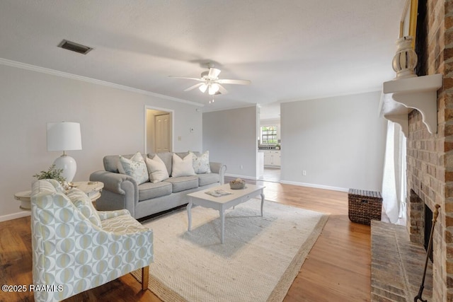 204 Eva Dr, Lafayette, LA 70508 - living area with light wood finished floors, a brick fireplace, visible vents, baseboards, and ceiling fan