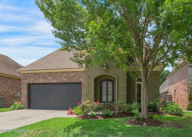 view of front of property featuring brick siding, an attached garage, a shingled roof, concrete driveway, and a front yard