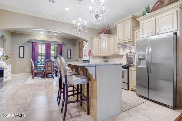 kitchen featuring ornamental molding, decorative backsplash, arched walkways, stainless steel appliances, and cream cabinets