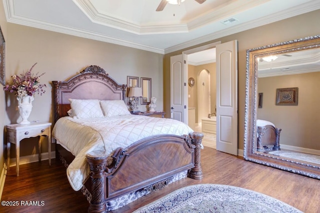 bedroom with arched walkways, ornamental molding, visible vents, and wood finished floors