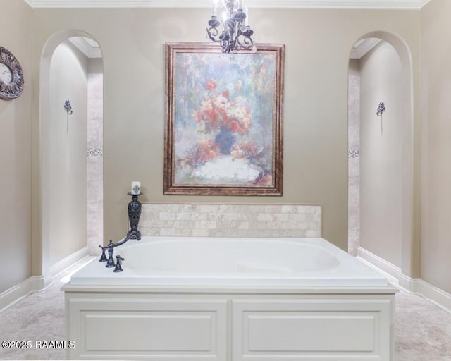 bathroom featuring a bath and a chandelier