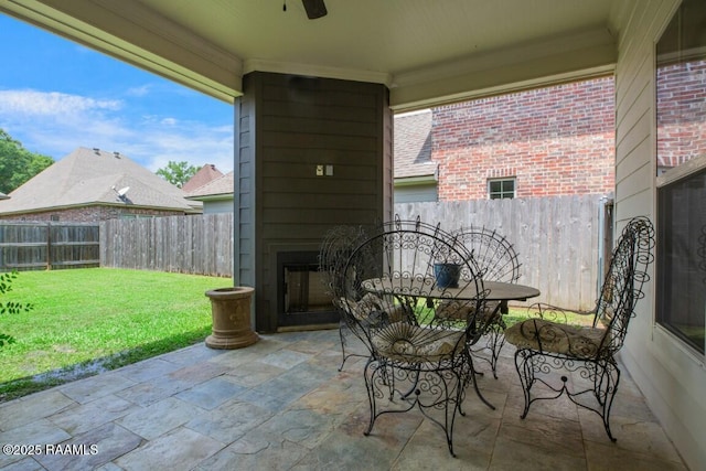 view of patio with ceiling fan, exterior fireplace, and a fenced backyard