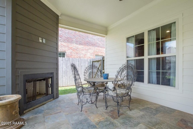 view of patio / terrace featuring outdoor dining area, an outdoor fireplace, and fence
