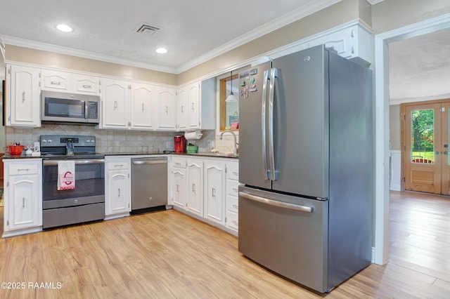 kitchen featuring dark countertops, appliances with stainless steel finishes, visible vents, and white cabinetry