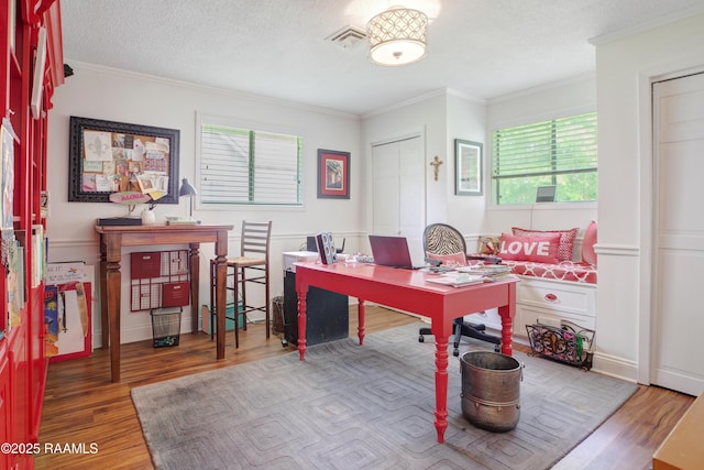 office featuring visible vents, crown molding, a textured ceiling, and wood finished floors