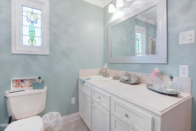bathroom with toilet, ornamental molding, vanity, and baseboards