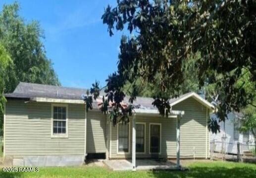 back of property with a yard, fence, and a patio area