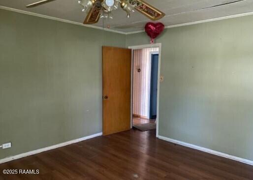 spare room featuring a ceiling fan, ornamental molding, baseboards, and wood finished floors