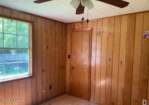 spare room with wooden walls and ceiling fan