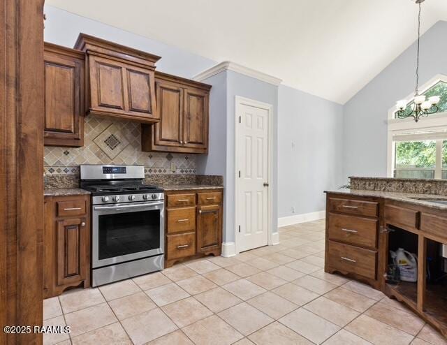 kitchen featuring stainless steel gas range, backsplash, light tile patterned flooring, pendant lighting, and baseboards