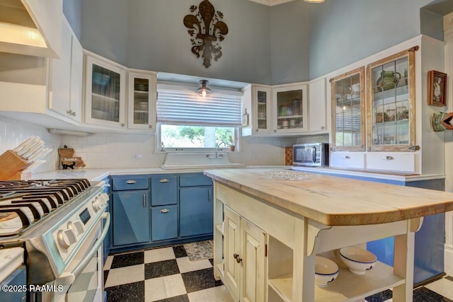 122 Lee St, New Iberia, LA 70560 - kitchen featuring blue cabinetry, stainless steel gas stove, wood counters, tile patterned floors, and a sink