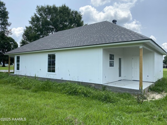203 Deerfield Loop, Duson, LA 70529 - back of property featuring a shingled roof, a patio, and a yard