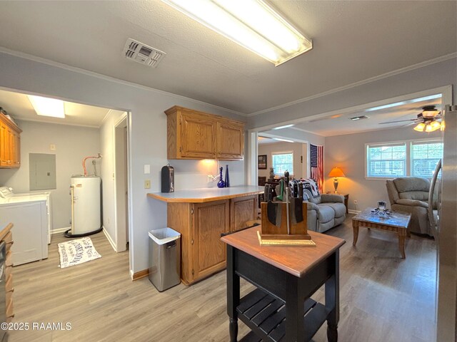 230 Glenwood Ave, Morgan City, LA 70380 - kitchen with washer and dryer, water heater, light wood-style flooring, light countertops, and crown molding