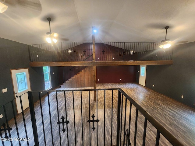 stairs featuring a ceiling fan, lofted ceiling, and wood finished floors