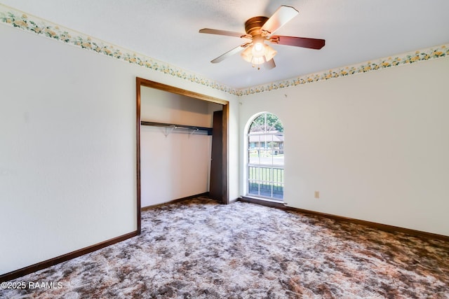 unfurnished bedroom with ceiling fan, carpet, a closet, and baseboards