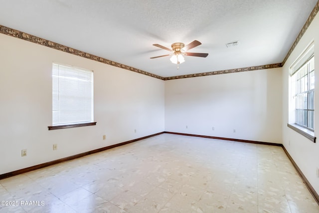spare room featuring ceiling fan, light floors, baseboards, and visible vents
