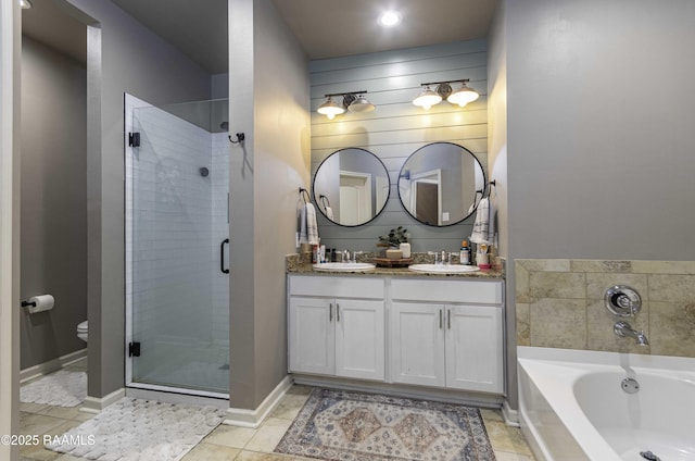 bathroom with a stall shower, a bath, double vanity, and a sink