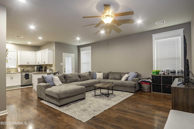 living area with visible vents, a ceiling fan, dark wood-type flooring, and recessed lighting