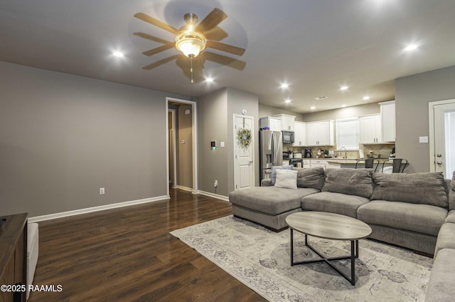 living area featuring dark wood-style flooring, baseboards, a ceiling fan, and recessed lighting