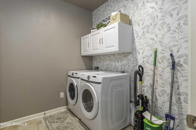 clothes washing area featuring baseboards, separate washer and dryer, wallpapered walls, and cabinet space