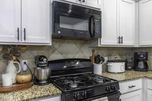 kitchen featuring light stone countertops, decorative backsplash, black appliances, and white cabinets