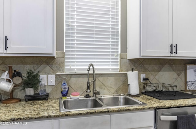 kitchen featuring a sink, backsplash, white cabinets, and dishwasher