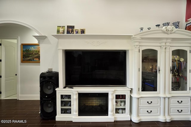 living area featuring baseboards and dark wood-style flooring