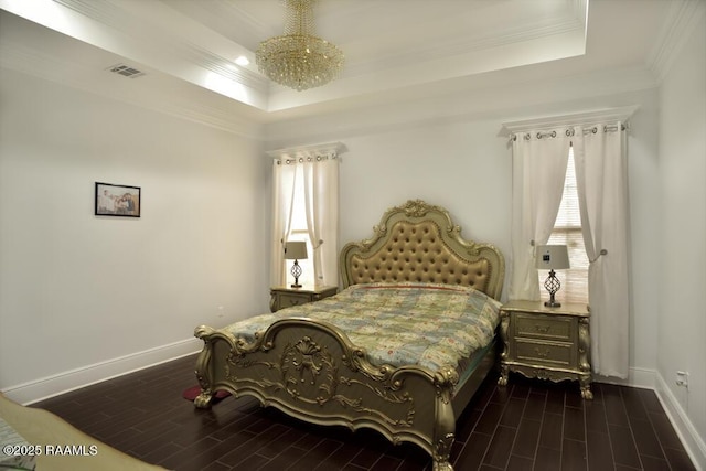 bedroom with a tray ceiling, baseboards, crown molding, and dark wood finished floors