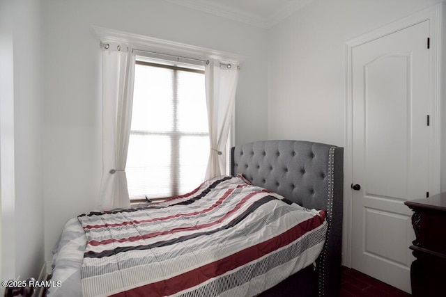 bedroom featuring crown molding and dark wood-style floors