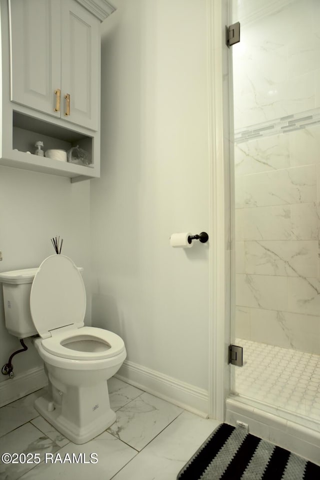 bathroom featuring marble look tile flooring, baseboards, toilet, and a stall shower