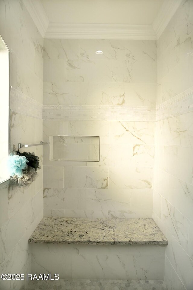 bathroom featuring crown molding and a tile shower