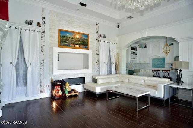 4300 Gerald James Dr, New Iberia, LA 70560 - living room featuring wood finished floors, arched walkways, ornate columns, crown molding, and a chandelier