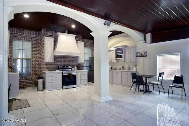 4300 Gerald James Dr, New Iberia, LA 70560 - kitchen with stainless steel electric range, custom exhaust hood, light marble finish floors, light countertops, and wood ceiling
