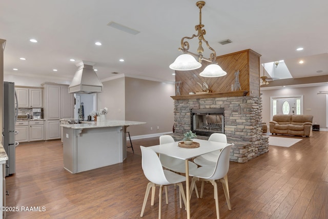 16634 W La Highway 330, Abbeville, LA 70510 - dining area featuring crown molding, baseboards, a fireplace, wood finished floors, and recessed lighting