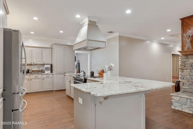16634 W La Highway 330, Abbeville, LA 70510 - kitchen with appliances with stainless steel finishes, premium range hood, a kitchen breakfast bar, light wood-style floors, and crown molding