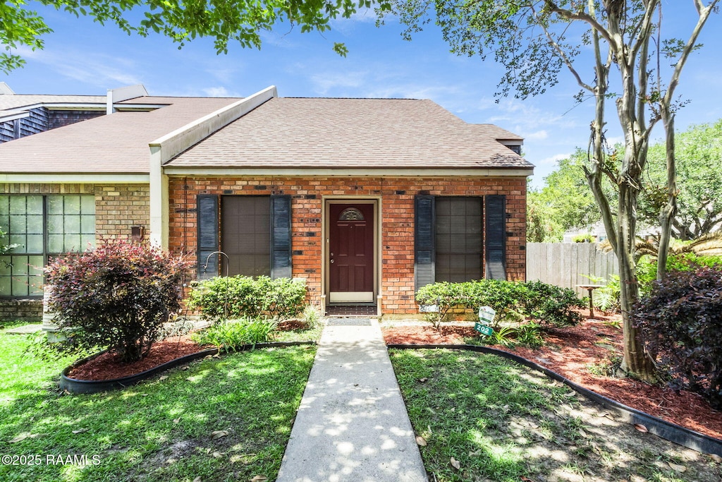 202 Long Plantation Blvd Unit A, Lafayette, LA 70508 - bungalow-style home with roof with shingles, brick siding, and fence