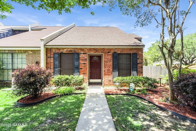 202 Long Plantation Blvd Unit A, Lafayette, LA 70508 - bungalow-style home with roof with shingles, brick siding, and fence