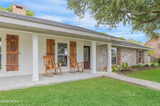 513 Emmeline St, New Iberia, LA 70563 - entrance to property featuring a porch, a lawn, and a chimney