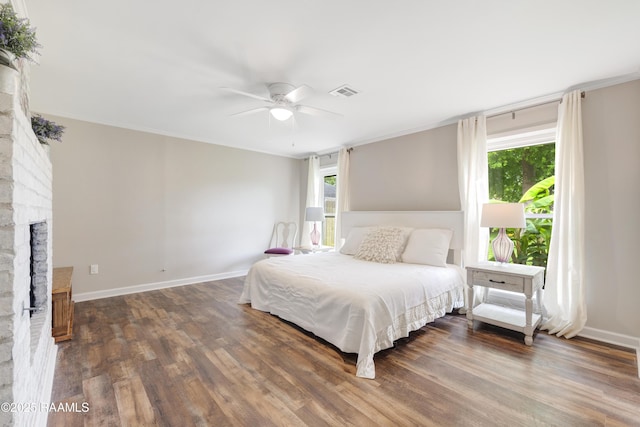 513 Emmeline St, New Iberia, LA 70563 - bedroom featuring wood finished floors, crown molding, baseboards, a fireplace, and ceiling fan