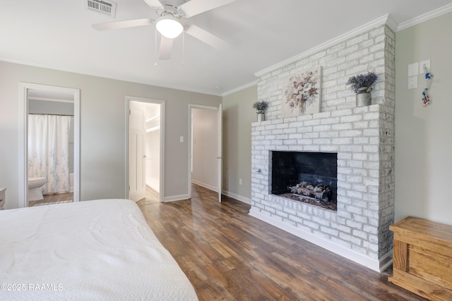 513 Emmeline St, New Iberia, LA 70563 - bedroom with wood finished floors, crown molding, a brick fireplace, ensuite bath, and baseboards