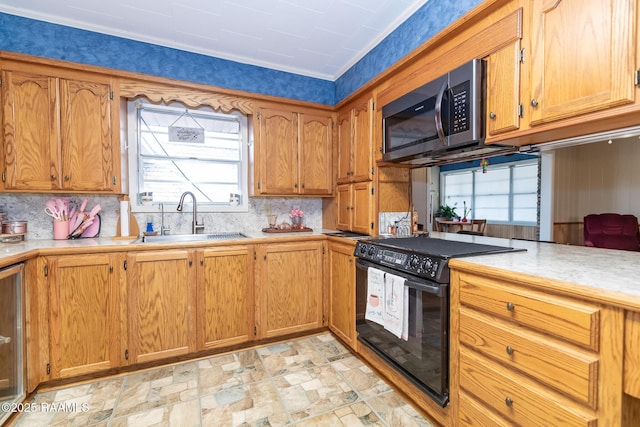 2405 S Chataignier Rd, Ville Platte, LA 70586 - kitchen with black electric range, a sink, stainless steel microwave, light countertops, and decorative backsplash