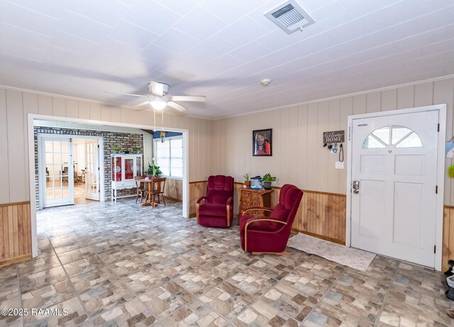 2405 S Chataignier Rd, Ville Platte, LA 70586 - foyer entrance with wood walls, french doors, ceiling fan, and ornamental molding