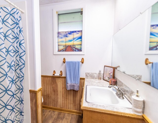 2405 S Chataignier Rd, Ville Platte, LA 70586 - bathroom featuring wood finished floors, vanity, a shower with curtain, wood walls, and wainscoting