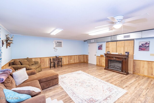 2405 S Chataignier Rd, Ville Platte, LA 70586 - living area featuring a wainscoted wall, light wood-type flooring, wooden walls, ceiling fan, and a wall mounted air conditioner